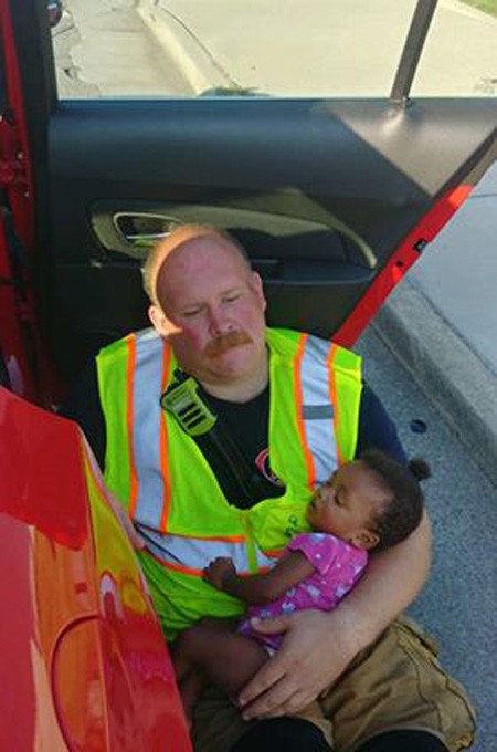 Blazek, vẻ mặt mệt mỏi, vẫn bế chặt bé gái trong tay để bé yên tâm chìm vào giấc ngủ. Ảnh: Chattanooga Fire Department.