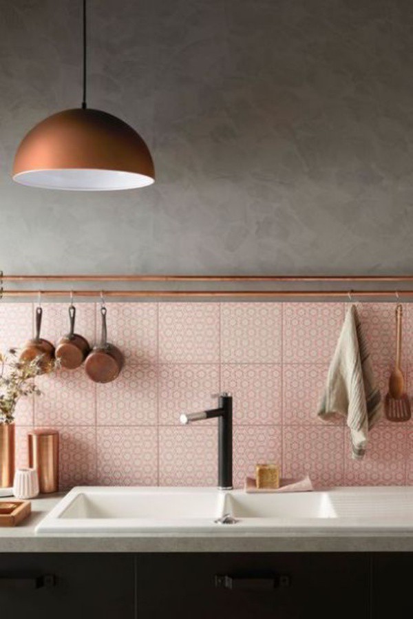 Một khoảng bếp nhỏ màu hồng của gạch ốp tường sẽ thêm ấn tượng khi có “đường ray” màu đồng để treo vật dụng nấu nướng gọn gàng.