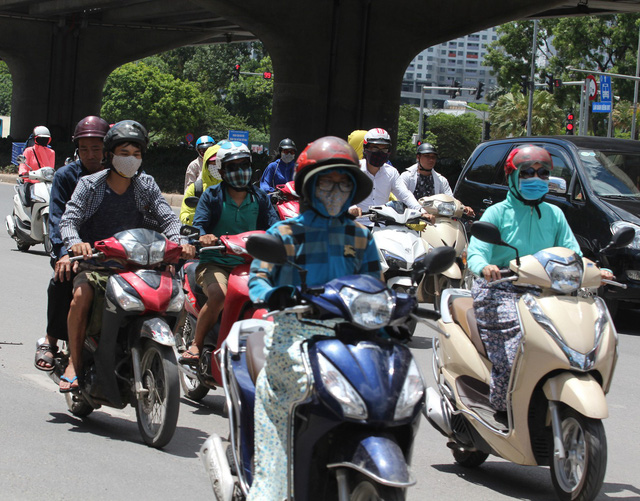 Buổi trưa, nắng như đổ lửa, người đi đường phải đeo khẩu trang, mặc áo chống nắng kín người.