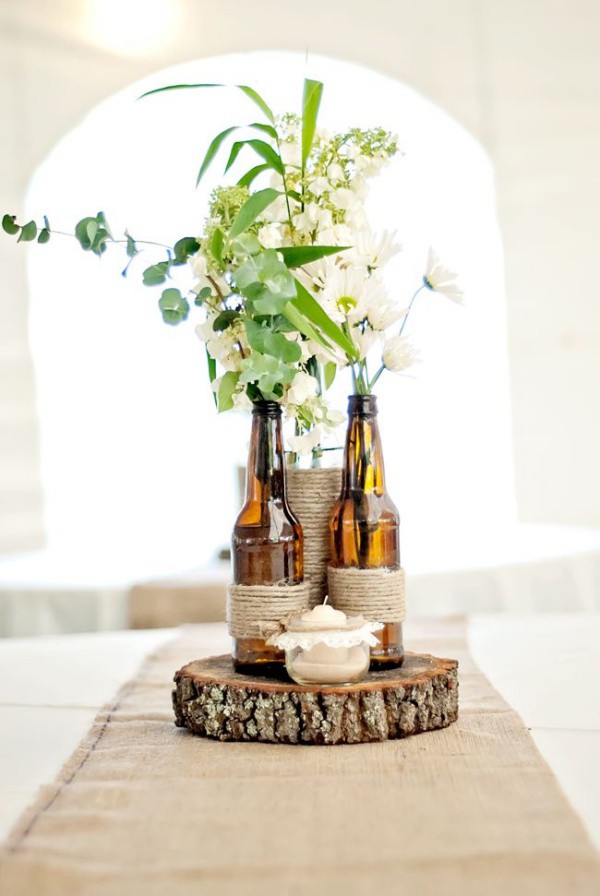 Đế bằng gỗ được đặt thêm nến, chai thủy tinh để góc bàn ăn đẹp như mơ với những loại hoa tự cắm.