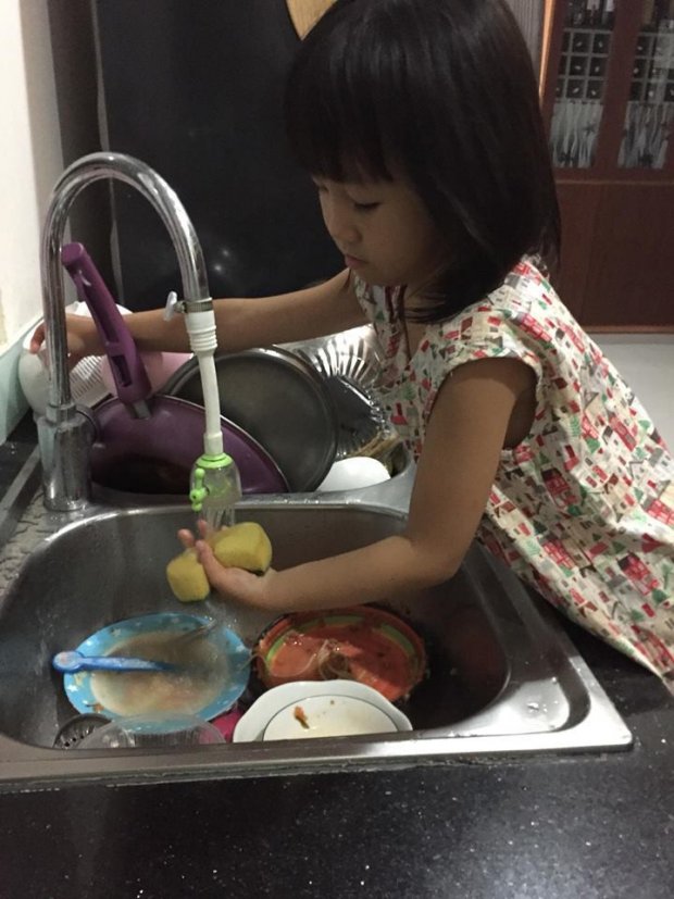 Bé Ngọc 5 tuổi giúp mẹ rửa bát.