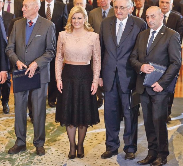 Bà Kolinda vô cùng duyên dáng khi đứng cùng hàng ngũ các nhà lãnh đạo với chiếc váy ren phối màu khéo léo giữa tông hồng bụi và sắc đen tuyền.