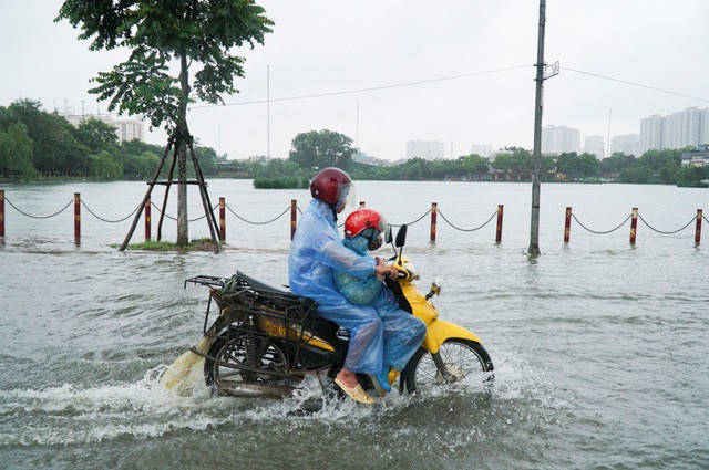 Nước dâng cao khiến người dân không thể phân biệt được giữa mặt đường và mặt hồ Văn Quán nếu như không có hàng cọc bên đường.
