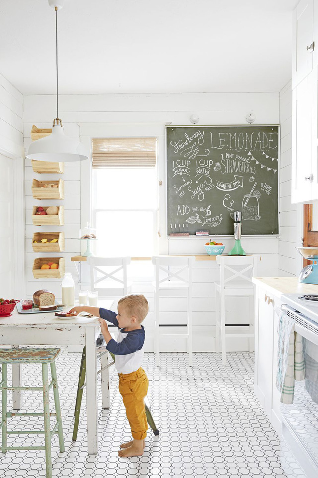 Vì nhà có 4 đứa trẻ nên phòng bếp cũng gắn thêm một bảng đen để note những ghi chú nhỏ trong ngày. Ngoài ra. các đồ nội thất và tường sử dụng màu trắng tinh hiện đại.