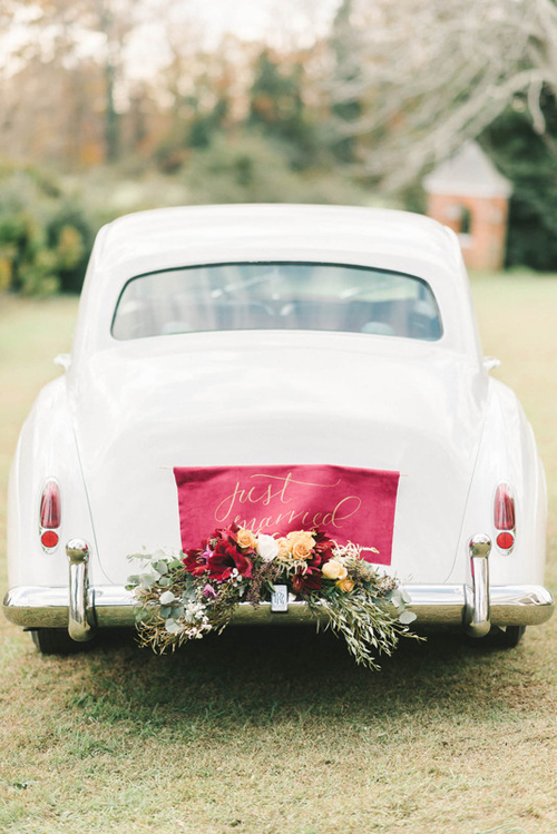 2. Tấm thẻ thông báo tình trạng mới kết hôn bằng vải có màu sắc sặc sỡ trên chiếc xe cổ màu trắng. Phông chữ mềm được sử dụng kết hợp với một khóm hoa rực rỡ. 