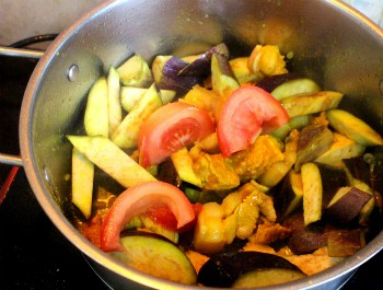 Bước 5: Cho thêm cà tím, cà chua vào nồi thịt đã xào. Đổ vừa lượng nước, thêm gia vị vừa miệng đun nhỏ lửa cho cà chín mềm. Nhặt hành lá, tía tô, lá lốt rửa sạch rồi thái nhỏ. Cho các loại rau gia vị vào nồi đảo đều rồi tắt bếp.