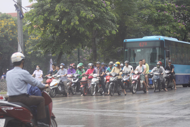 Chùm ảnh: Hà Nội chớm lạnh, buổi sáng người dân mặc áo khoác, đội mưa đi làm - Ảnh 2.