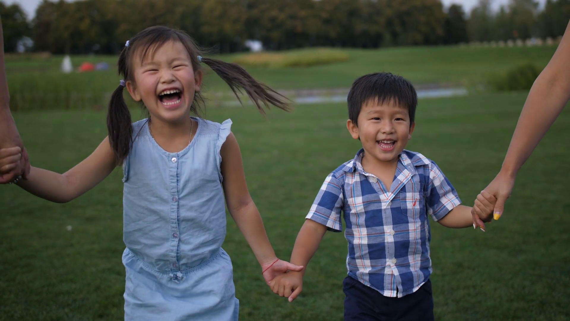 videoblocks-adorable-laughing-asian-siblings-holding-han