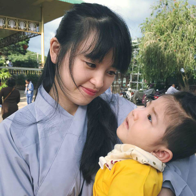 Hình ảnh em bé Lào Cai bụ bẫm đáng yêu trong bộ váy tím khi được bố nuôi bế khiến nhiều người chú ý - Ảnh 3.