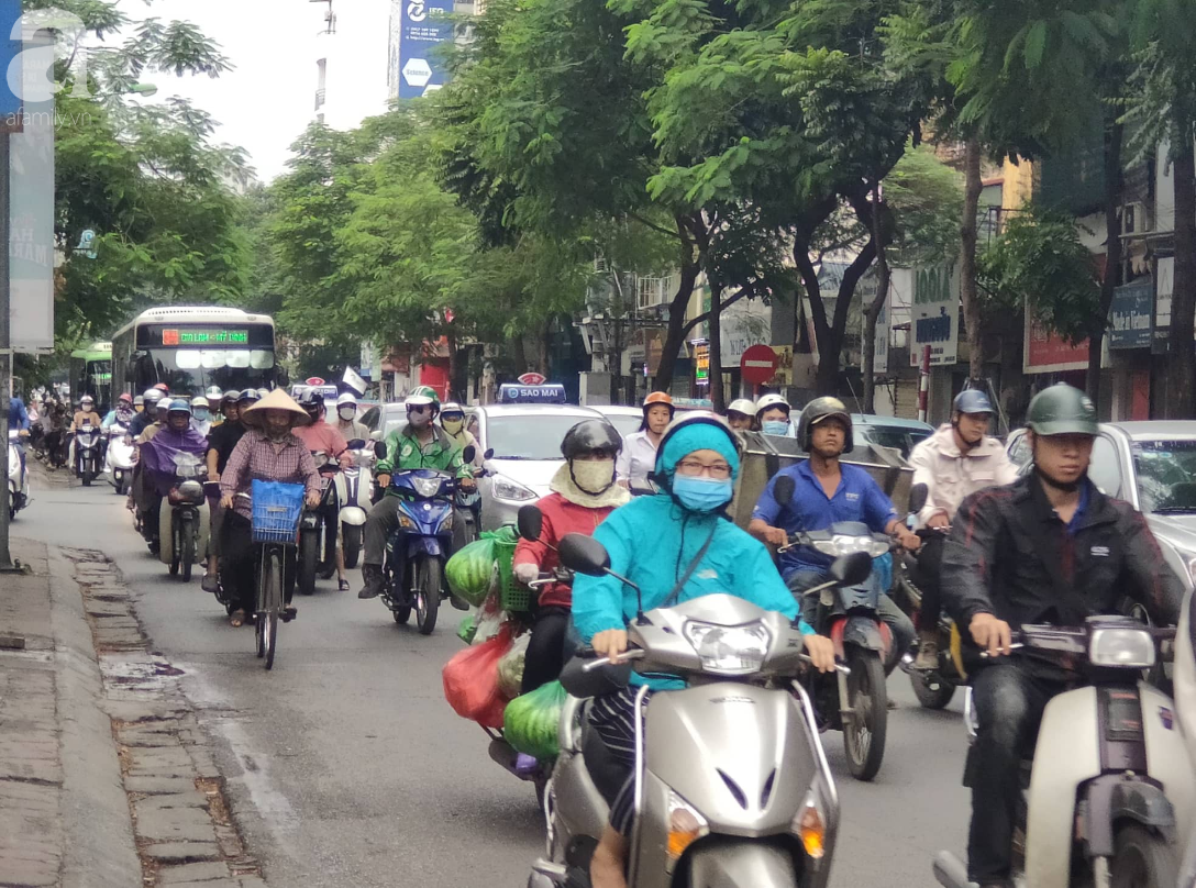 Hà Nội: Không khí lạnh tràn về, nhiệt độ giảm mạnh, người dân thích thú mặc áo ấm ra đường dưới trời mưa phùn - Ảnh 3.