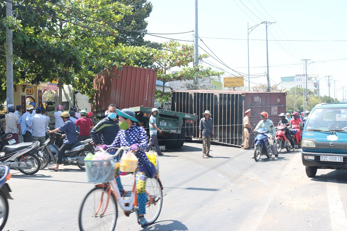 Kinh hoàng xe container nổ bánh mất lái kéo lê 5 xe máy, nhiều người bị thương - Ảnh 1.