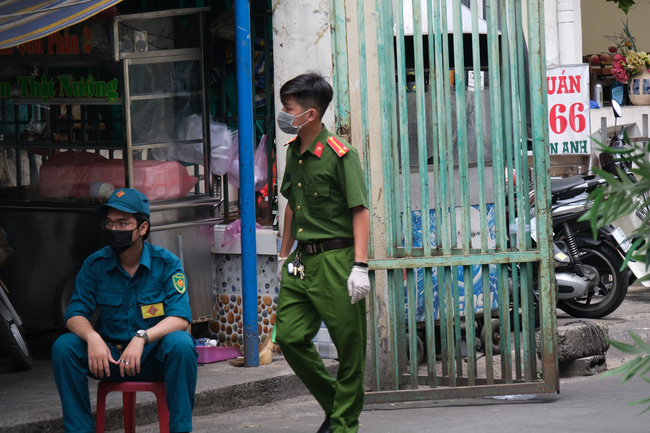 An ninh tại chung cư có ca nhiễm Covid-19 thắt chặt: Hàng rào đóng kín, cơm nước được tiếp tế thẳng vào trong - Ảnh 4.