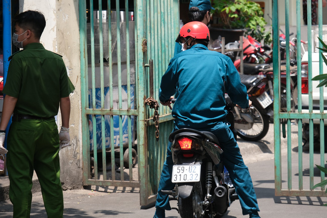 An ninh tại chung cư có ca nhiễm Covid-19 thắt chặt: Hàng rào đóng kín, cơm nước được tiếp tế thẳng vào trong - Ảnh 14.