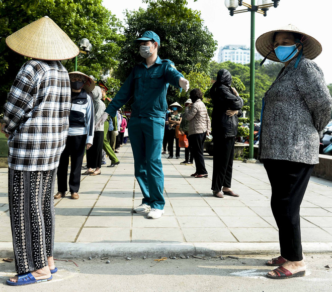 [Ảnh] Người dân xếp hàng kéo dài từ sân vận động đến sân nhà văn hoá ở Hà Nội đợi nhận gạo từ cây ATM gạo miễn phí - Ảnh 4.