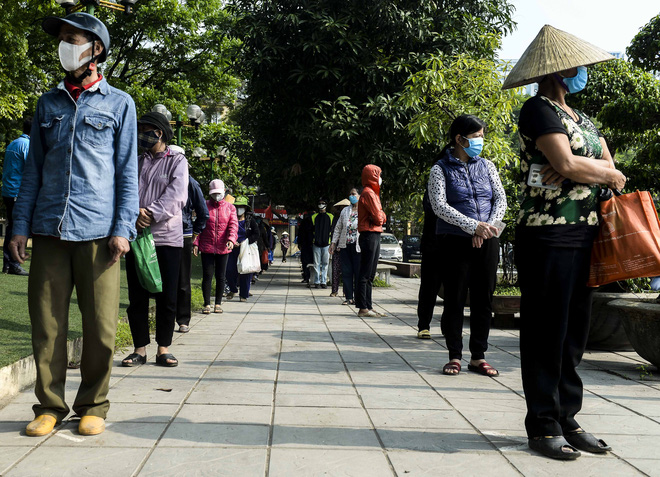 [Ảnh] Người dân xếp hàng kéo dài từ sân vận động đến sân nhà văn hoá ở Hà Nội đợi nhận gạo từ cây ATM gạo miễn phí - Ảnh 3.