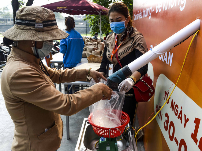 [Ảnh] Người dân xếp hàng kéo dài từ sân vận động đến sân nhà văn hoá ở Hà Nội đợi nhận gạo từ cây ATM gạo miễn phí - Ảnh 1.