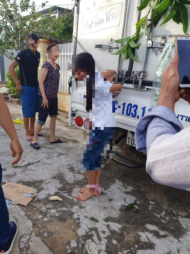 Bé gái ở Quảng Bình bị người thân trói quặt 2 tay vào thùng xe tải, cạnh đó là dòng chữ phạt trộm tiền - Ảnh 1.