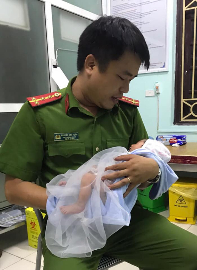 Hà Nội: Cảnh sát chăm sóc bé trai sơ sinh bị mẹ bỏ rơi trong đêm tối gần cánh đồng - Ảnh 1.