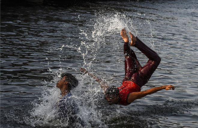 24h qua ảnh: Cậu bé đeo khẩu trang bơi trong công viên ngập lụt do nước sông dâng cao ở TQ - Ảnh 9.