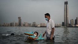 24h qua ảnh: Cậu bé đeo khẩu trang bơi trong công viên ngập lụt do nước sông dâng cao ở TQ
