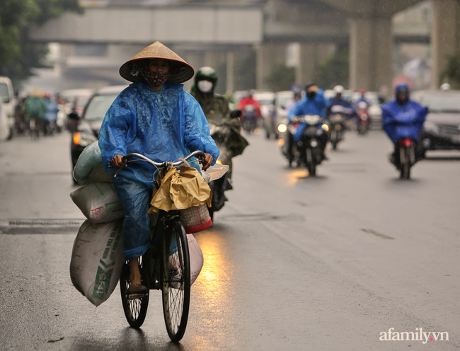 Ảnh: Sau một đêm trở gió Hà Nội mưa lạnh xuống đến 20 độ C, người dân trùm áo mưa co ro ra đường - Ảnh 2.