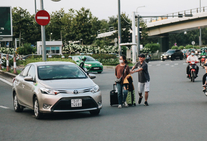 Khổ như hành khách ở Tân Sơn Nhất: Đội nắng mang vác hành lý ra đường đón xe công nghệ - Ảnh 13.