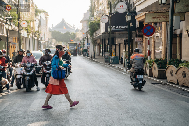 Ảnh: Hà Nội sáng đầu tuần rét lạnh dù có nắng, người dân trang bị áo ấm ra đường - Ảnh 1.