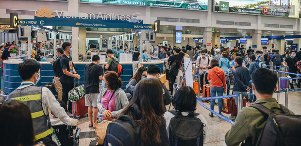 Sân bay Tân Sơn Nhất kích hoạt chế độ chống dịch nghiêm ngặt, hành khách mặc đồ bảo hộ về quê ăn Tết - Ảnh 1.