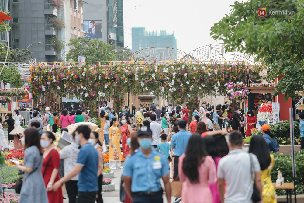 Ảnh: Người Sài Gòn xếp hàng đo thân nhiệt, đeo khẩu trang vào check in đường hoa Nguyễn Huệ - Ảnh 6.