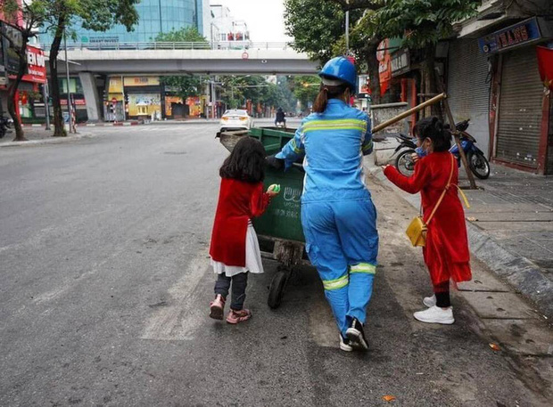 Người mẹ lao công trong bức ảnh cùng 2 con đi làm ngày mùng 1 Tết: Trẻ con thơ ngây lắm, chỉ cần được đi theo mẹ đã thích rồi - Ảnh 1.