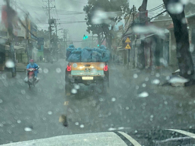 Xúc động khoảnh khắc xe bán tải biển 51 chở những bóng áo xanh choàng vai nhau dưới cơn mưa tầm tã - Ảnh 1.