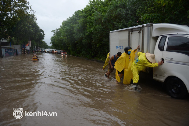 Ảnh: Mưa lớn kéo dài do ảnh hưởng của bão số 7, nhiều nơi ở Hà Nội ngập sâu, người dân chật vật di chuyển - Ảnh 9.