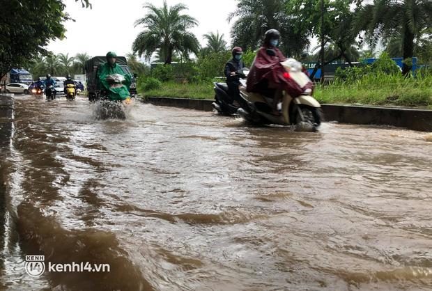 Ảnh: Mưa lớn kéo dài do ảnh hưởng của bão số 7, nhiều nơi ở Hà Nội ngập sâu, người dân chật vật di chuyển - Ảnh 2.